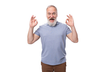 grandfather with a gray beard and mustache in a t-shirt and trousers joyfully and with astonishment...