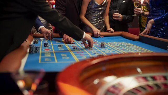 Successful Men and Women Partying in a Luxurious Casino. Young Anonymous People Gambling at a Roulette Table, Putting High Stakes Bets. Entertainment Industry and Glamorous Lifestyle Concept