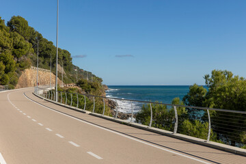 A long bike path overlooking the sea with no one around. - obrazy, fototapety, plakaty