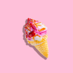 Christmas tree toy in the form of ice cream in a cone with a cherry isolated on a pink background.