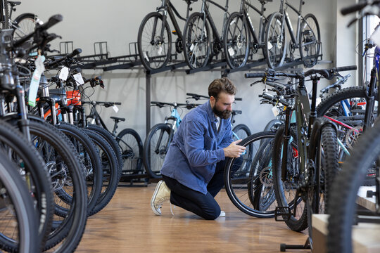 Adult male looking at electric bikes in a cycle store