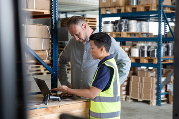 Employee in distribution warehouse being trained on paperwork to export products