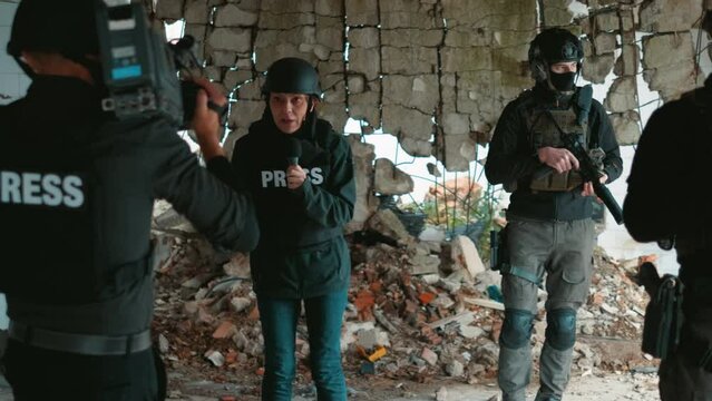 Television crew of war journalists reports live on the war zone at the moment of the explosion nearby. Panicked and frightened reaction of war correspondents and soldiers at the moment of the bombing