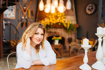 Portrait of attractive blonde woman at table in cozy house in retro style.