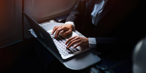 Successful Asian business woman, Business woman working in airplane cabin during flight on laptop...