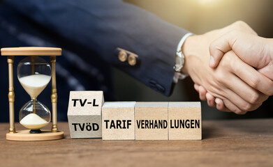Cubes form the German expression 'TV-L Tarifverhandlungen' (tariff negotiations). Symbol for...