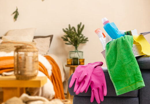 Cleaning before Christmas. Multicolored cleaning supplies. Sponges, rags and spray with festive decorations against background