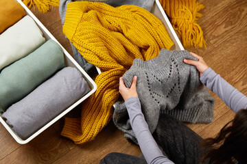 The hands of a woman with a knitted wool sweater. The concept of restoring order, cleaning,...