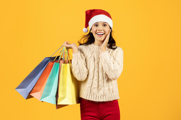 lady holding bags after Christmas sale shopping on yellow background
