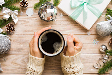 Woman holding cup of coffee. Woman hands holding a mug with hot coffee. Winter and Christmas time concept