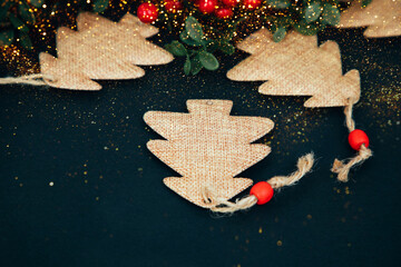 Christmas greeting background with empty space. Brown Christmas trees on a dark background. Top view
