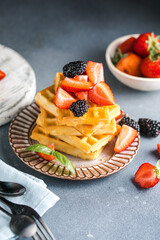 Waffles and Strawberries stacked on a plate. Belgian homemade waffles