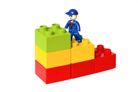 Miniature Building Block Person Ascending Corporate Stairs: Career Advancement Image. Lego blocks. Novosibirsk, Russia - October 26, 2023.