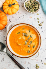 Roasted pumpkin and carrot soup with cream and pumpkin seeds