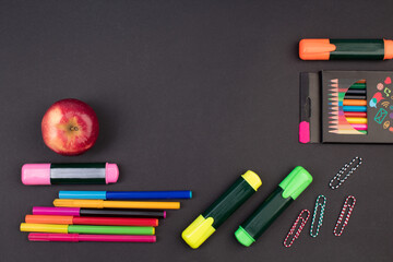 Back to school. Stationery on a black table. Office desk with copy space. Flat lay.