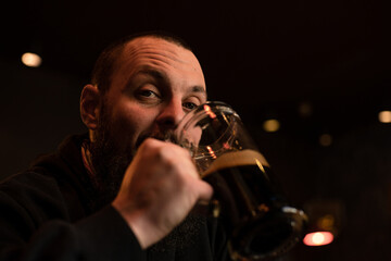 bearded man holds glass of beer while sitting in pub. Beer time. Alcohol drinks
