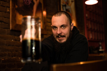 bearded man holds glass of beer while sitting in pub. Beer time. Alcohol drinks