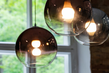 Round glass lampshades with  glowing tungsten lamps inside