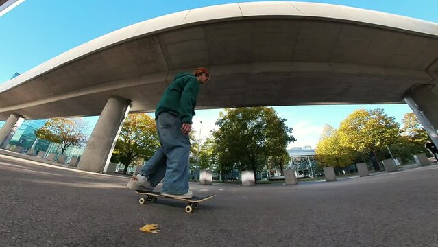 Male skateboarder training in urban car parking area