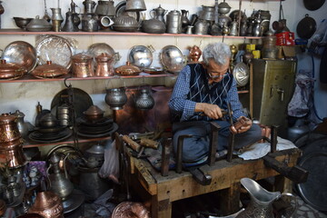 A tinsmith, in his, tinsmith's shop,The master, of working, with copper, in his shop