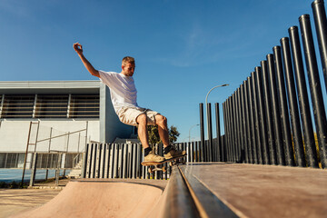 Energetic man riding skateboard on ramp in skate park