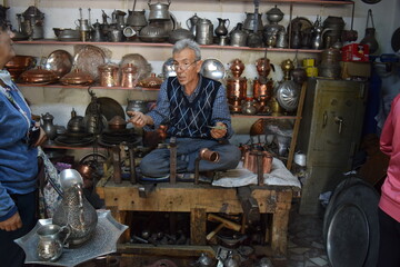 A tinsmith, in his, tinsmith's shop,The master, of working, with copper, in his shop