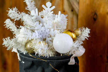 Details of the Christmas interior. Textile basket with a Christmas composition of white spruce twigs, snowflakes, balls.