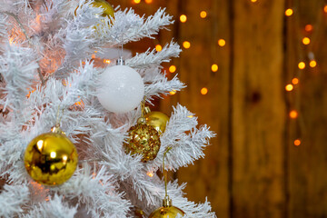 Details of the Christmas interior. Branches of a white Christmas tree with golden and white balls.