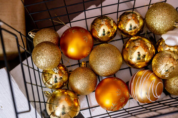 Details of the Christmas interior. Metal basket with golden Christmas balls.