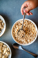 Set of various tasty breakfast cereals on light grey table, flat lay top view