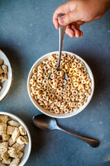 Set of various tasty breakfast cereals on light grey table, flat lay top view