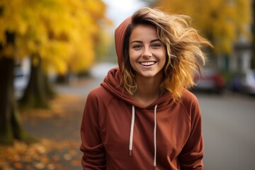 Young woman is smiling and standing outdoors