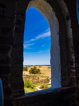 Fototapeta Blue sky and coast seen from window in stone building
