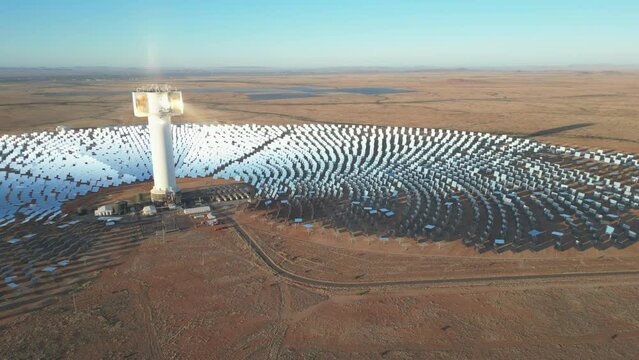 Slowly fly past vast Khi Solar One array. Light reflected from mirrors to tower
