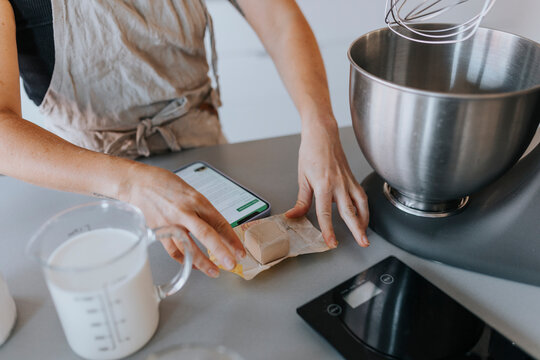 Mid section of woman unpacking fresh yeasts on kitchen worktop