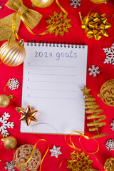 Fototapeta na wymiar New Year resolution list, goals and plans. Notepad for to do new year list, on red background with Christmas golden decoration, fir tree balls and baubles top view copy space