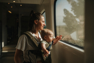 Mother with baby looking through train window