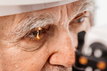 Close-up of an eye on an ophthalmology examination of an elderly man. The concept of advertising...