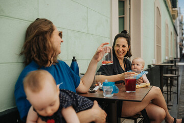 Mothers with babies relaxing in sidewalk cafe