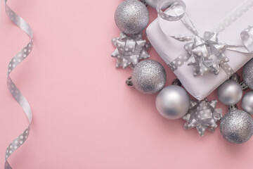 Christmas background white present box with christmas silver tree toys at the pink background,copy space,top view photo.