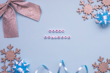 Christmas composition christmas decoration silver color and inscription Happy Holidays at the blue background.,copy space,top view photo.