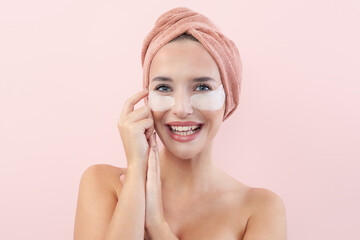 Skincare. Very happy young woman laughing, applying cosmetic eye patches mask, reduces wrinkles,...