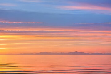 Naklejka na ściany i meble 穏やかな湖面：オレンジ、ピンク、青のグラデーションが広がる空と、その色が静かな湖面に反射し、地平線は山々のシルエットで描かれている、日の出または日没の風景