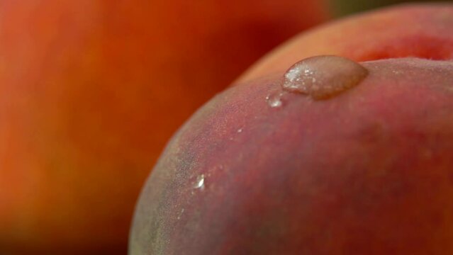 drop of water flowing down the side of a ripe red juicy peach