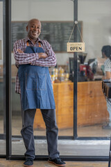 Full size protrait of a healthy retired black senior man stands proudly at his new private business. Startup business owner. SME entrepreneurs. © Wasana