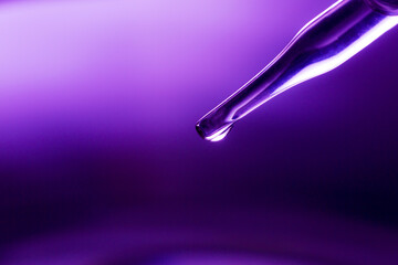 Test tube, medical or science laboratory concept, liquid droplets with droplets in purple tone background, close-up, macro image.