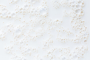 Macro milk close-up texture,Over head close up full frame background detail view of frothy white milk creating bubbles, indoors. Macro still life view of liquid milk drink.