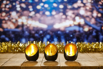 Black and gold christmas candles on wooden big table and free space for your decoration. Wooden...