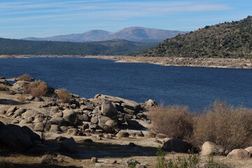 Fototapeta na wymiar El Burguillo Reservoir, Avila, Spain, November 13, 2023: Vegetation, mountains and large stones in the El Burguillo Reservoir, Avila, Spain