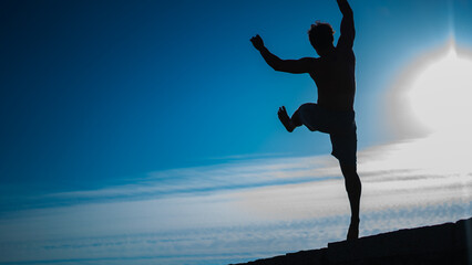 silhouette of a man who jumps while parkour session